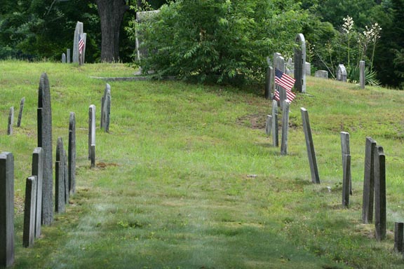A side view of two headstone rows going up a small hill