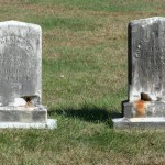 2 headstones decaying from the bottom