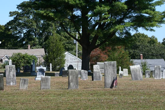 A group of headstones, note the house in back